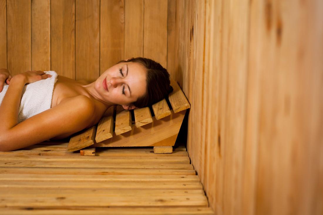 woman lying down in an infrared sauna made out of Finnish Spruce