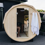 Front view of a wood fired barrel sauna installed outdoors