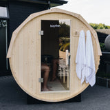 Front view of a wood fired barrel sauna installed outdoors
