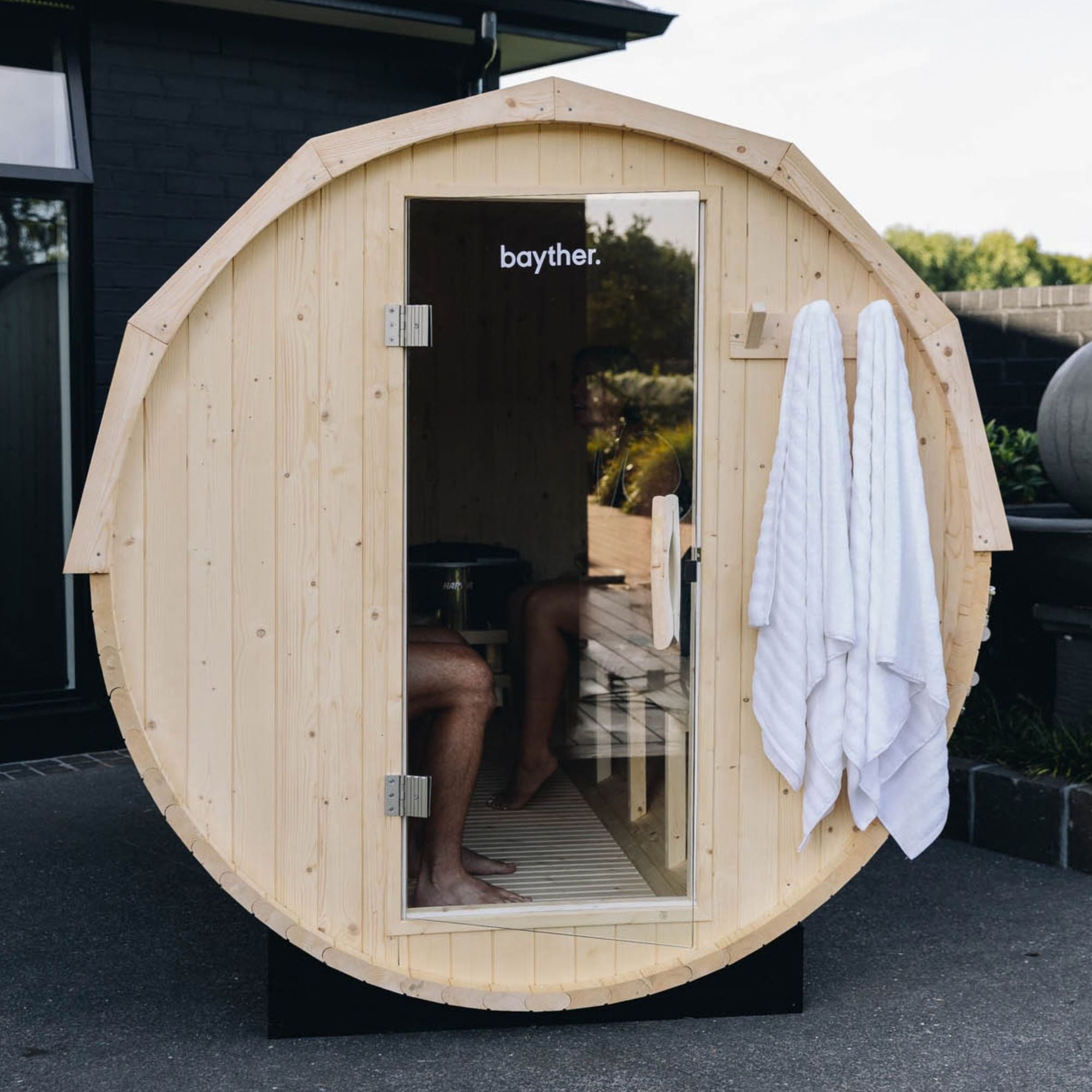 Front view of a wood fired barrel sauna installed outdoors